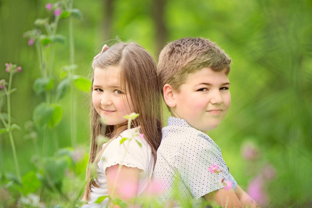 Brother and sister sitting in flowers