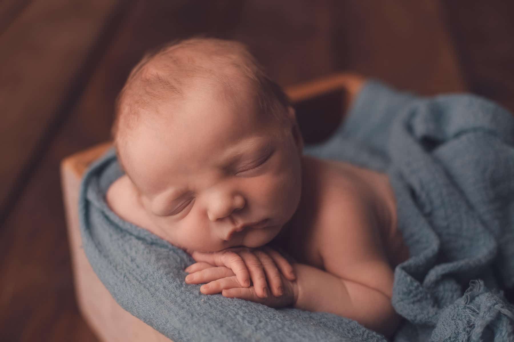 baby sleeping in wooden drawer during newborn photo shoot Glasgow