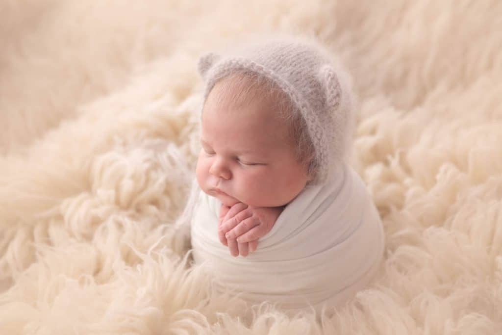 baby swaddled in white wrap
