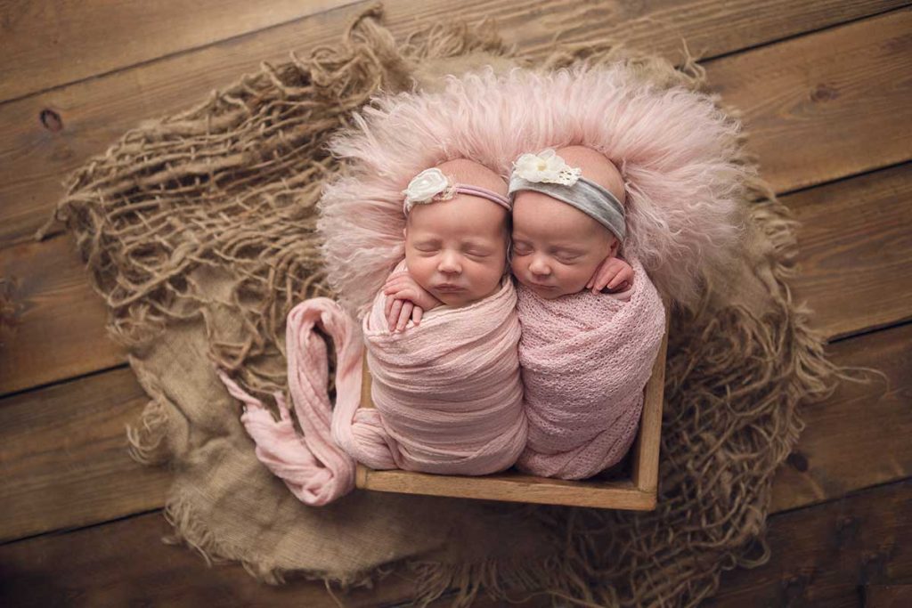 newborn twins in matching pink outfits photographed by dawn martin photography