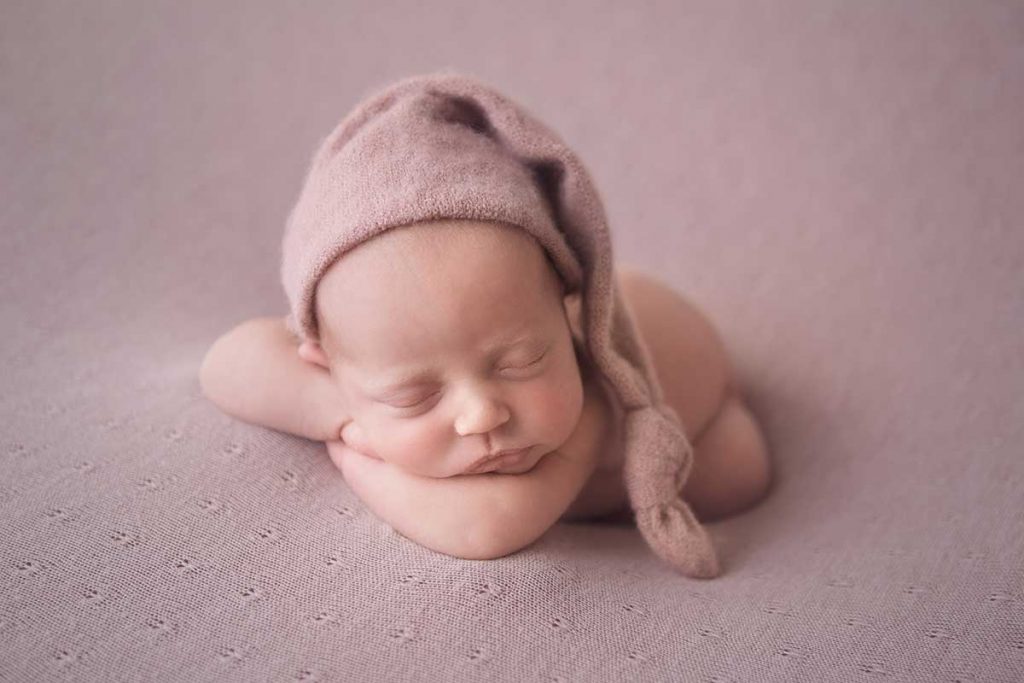 newborn baby girl sleeping on pink blanket