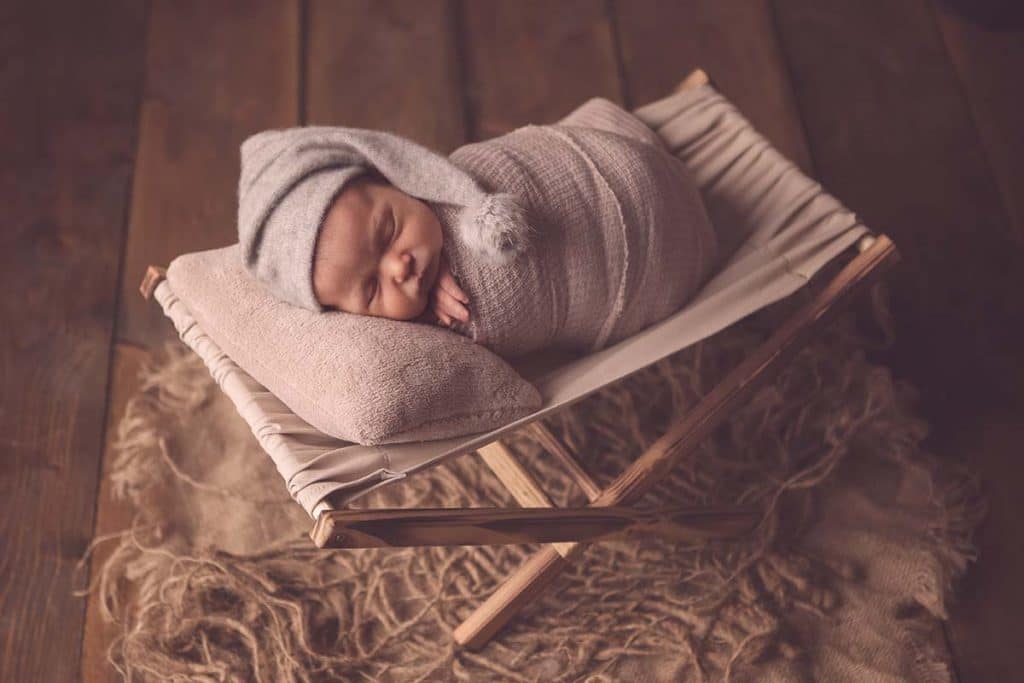 newborn baby girl snoozing in hammock