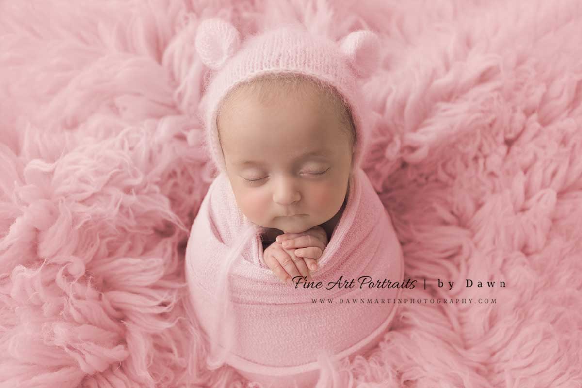 Newborn girl on pink blanket